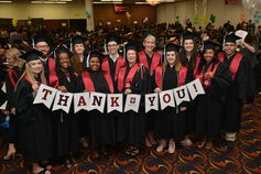 A group of IU Northwest graduates holds a sign reading "Thank you!"